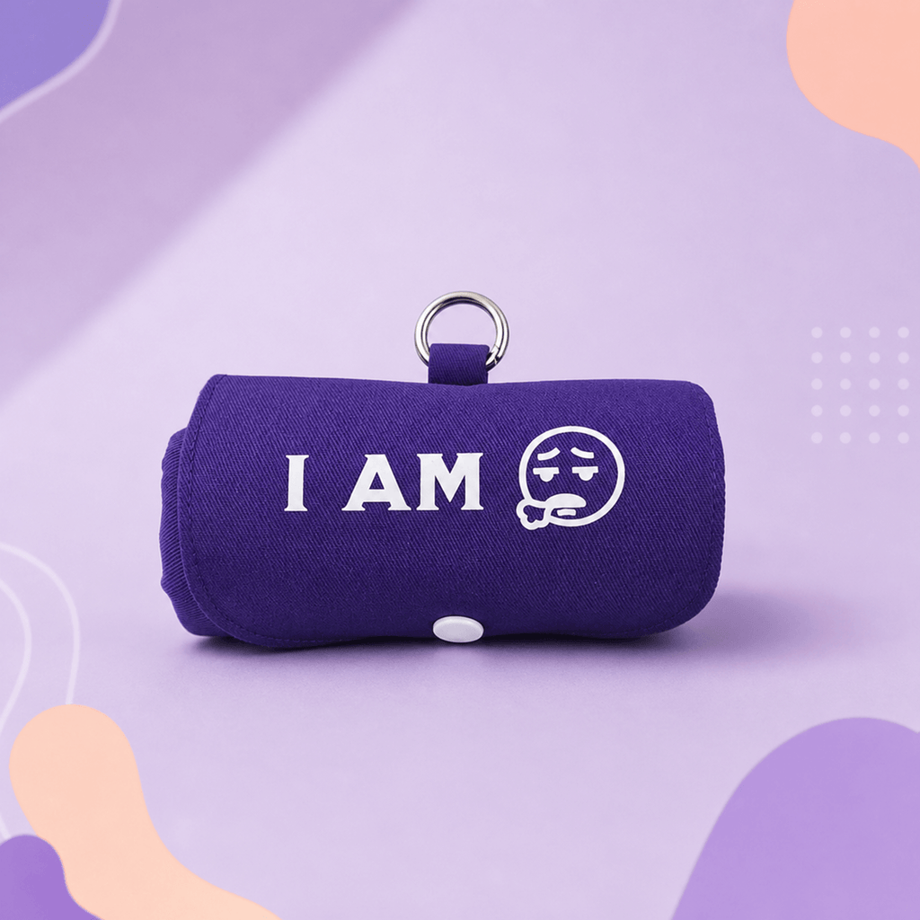 A purple fabric roll-up pouch with a metal key ring, featuring the white text 'I AM' and a white sad face graphic on the front, set against a purple and lavender abstract background. This product called Burritote.