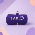 A purple fabric roll-up pouch with a metal key ring, featuring the white text 'I AM' and a white sad face graphic on the front, set against a purple and lavender abstract background. This product called Burritote.
